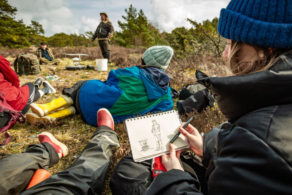 A woman sketching her observations in a forest.